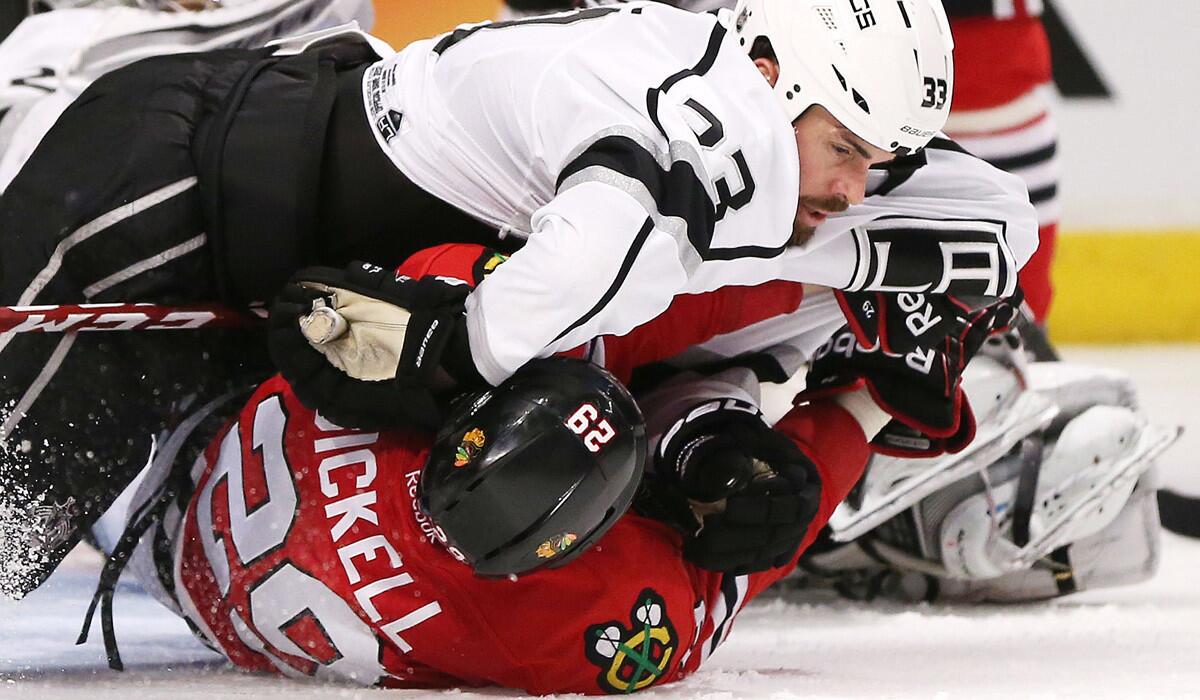 Kings defenseman Willie Mitchell roughs up Blackhawks winger Bryan Bickell, and perhaps the ice, during an altercation in the third period of Game 1 on Sunday.