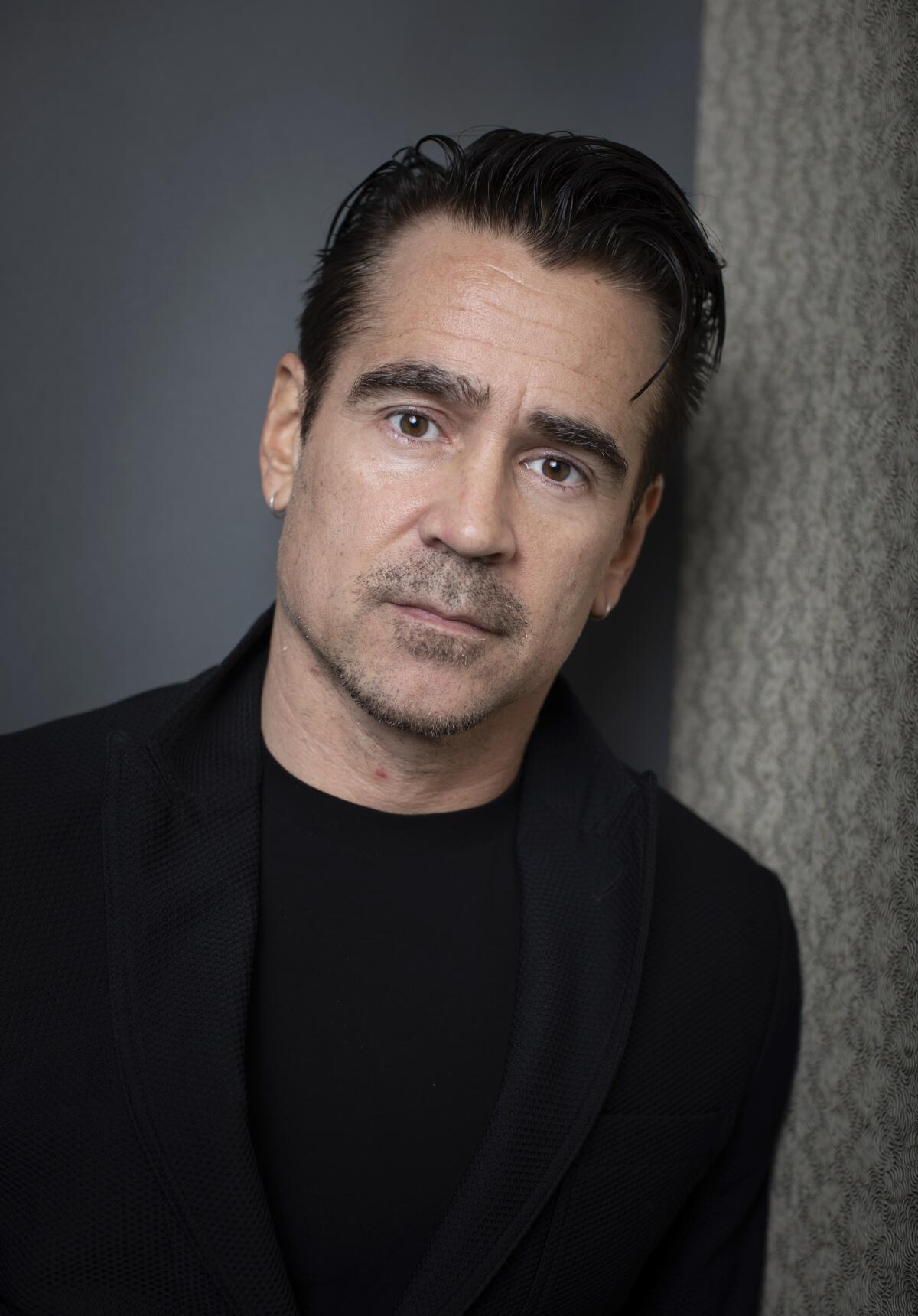 Colin Farrell wears a black sweater for a portrait.