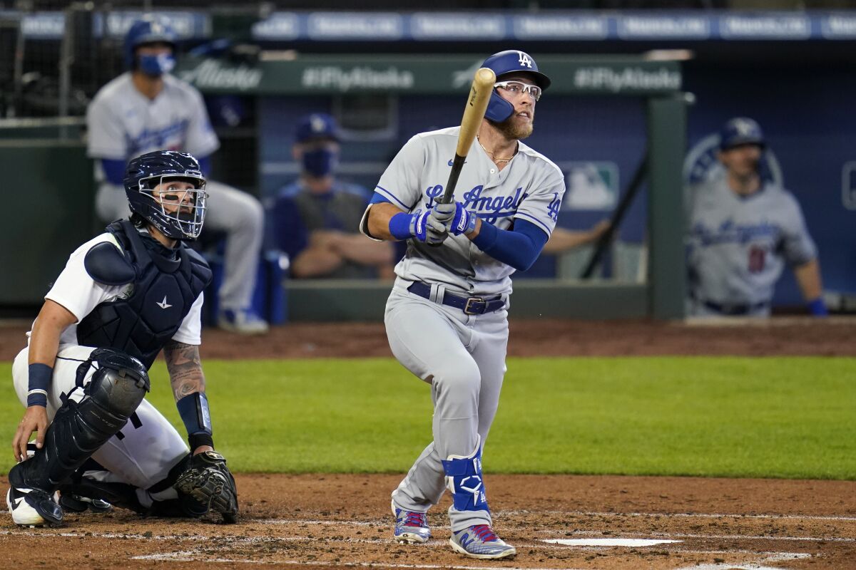 Dodgers designated hitter Matt Beaty hits a run-scoring double as Mariners catcher Joseph Odom watches.