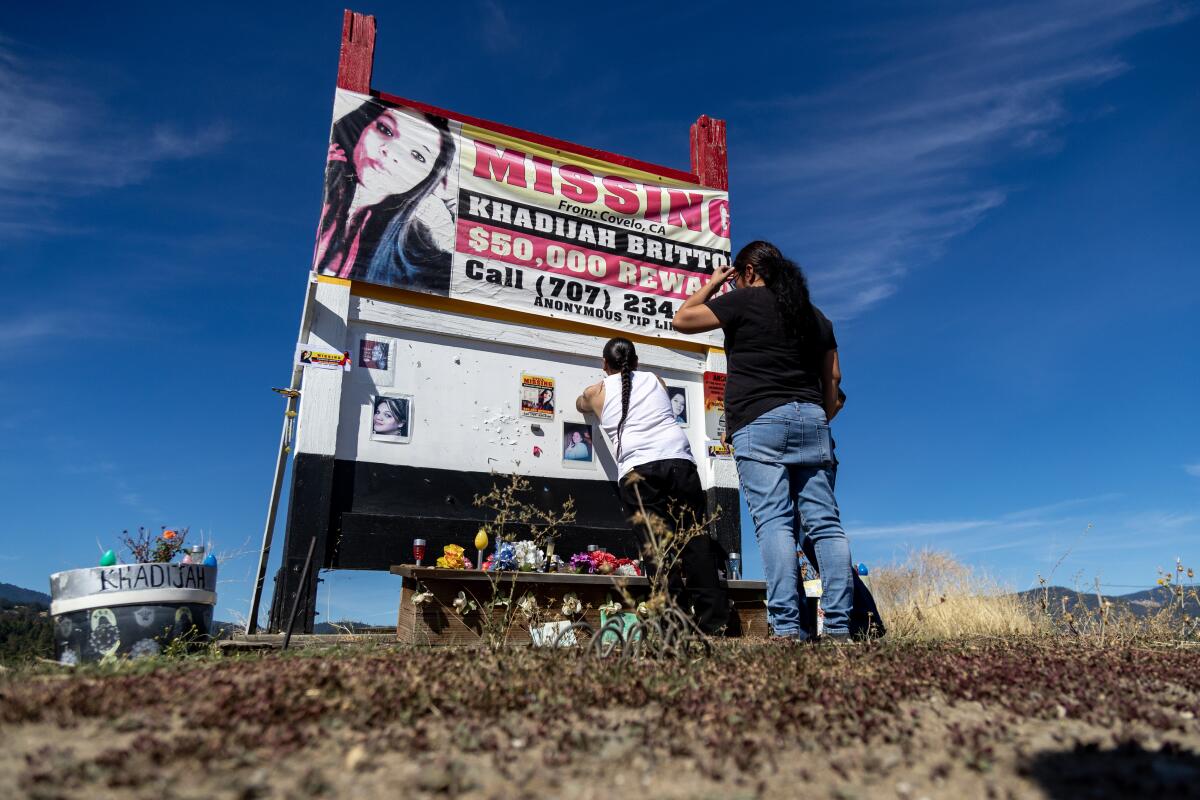 Family members put up new posters on a memorial for missing Khadijah Britton.