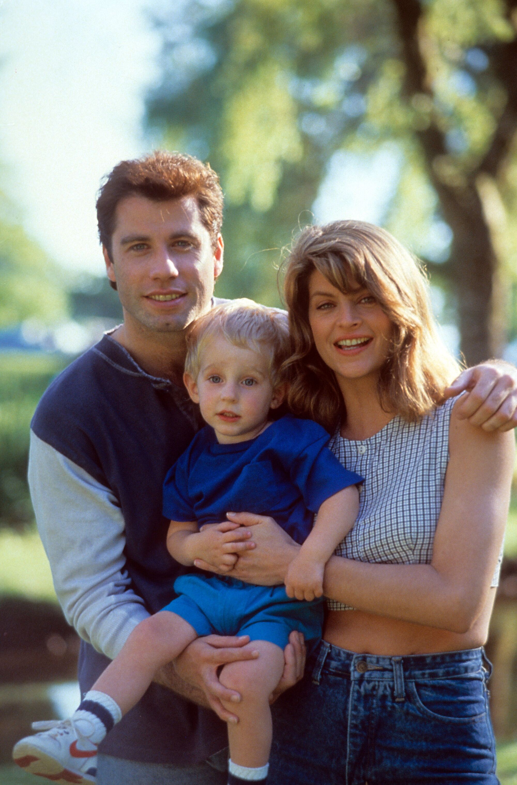 John Travolta and Kirstie Alley holding a young child.