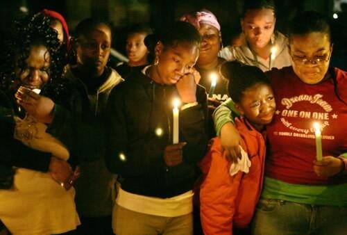 Yolanda Rice, far left, mother of Jacob Walker, 15, along with several of his cousins and dozens of other mourners, attends a memorial for the slain teen Monday evening in Bellflower. Prosecutors have so far declined to file charges against the man suspected of shooting Walker while the boy allegedly tried to steal marijuana plants grown for medicinal purposes.