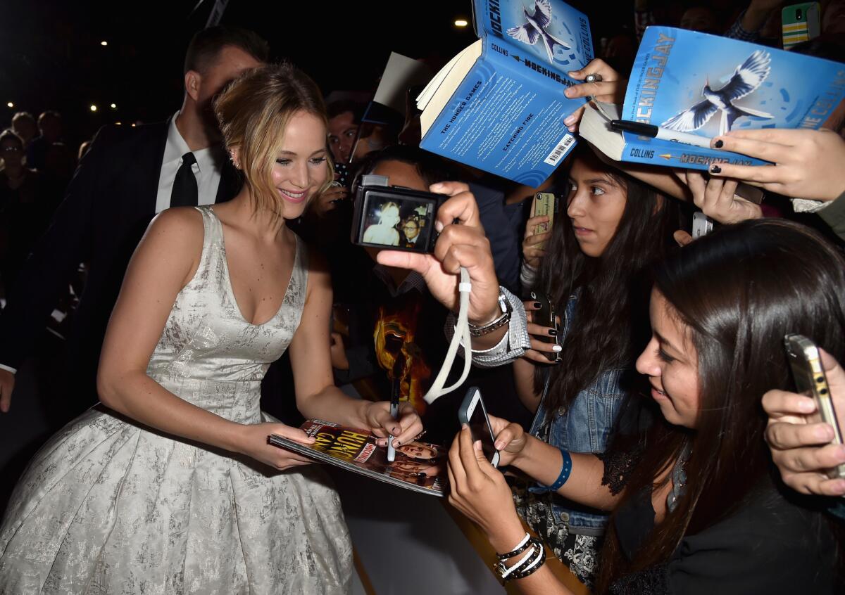 Jennifer Lawrence signs autographs at the premiere of Lionsgate's "The Hunger Games: Mockingjay — Part 1" at the Nokia Theatre on Monday.