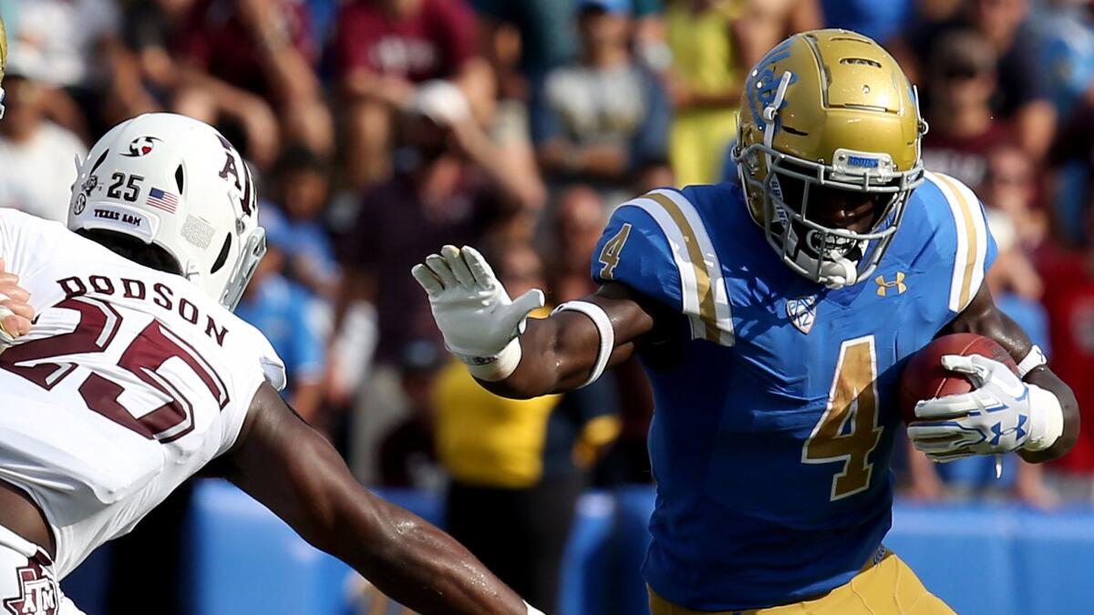 UCLA running back Bolu Olorunfunmi squeezes out extra yardage against Texas A&M on Sept. 3.