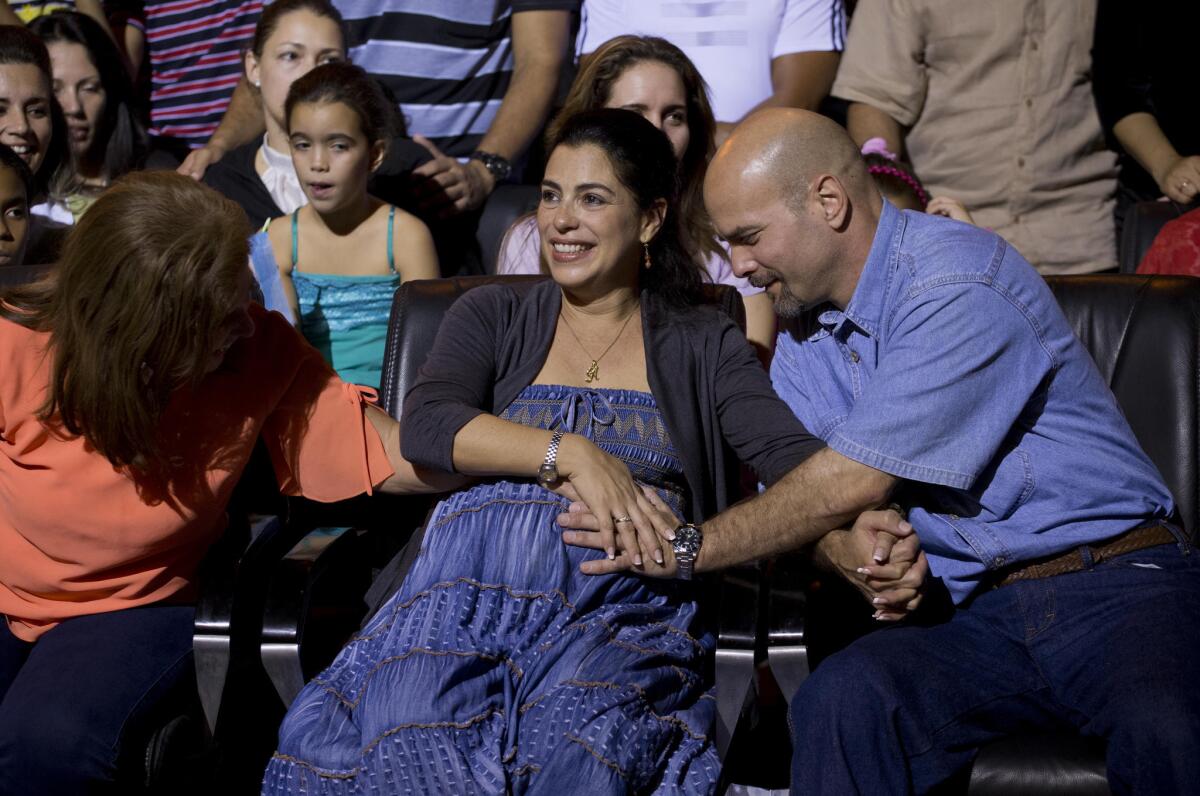 Gerardo Hernandez, a Cuban spy recently freed from a U.S. prison, touches the belly of his pregnant wife, Adriana Perez, during a concert in Havana on Dec. 20. They are expecting a girl.