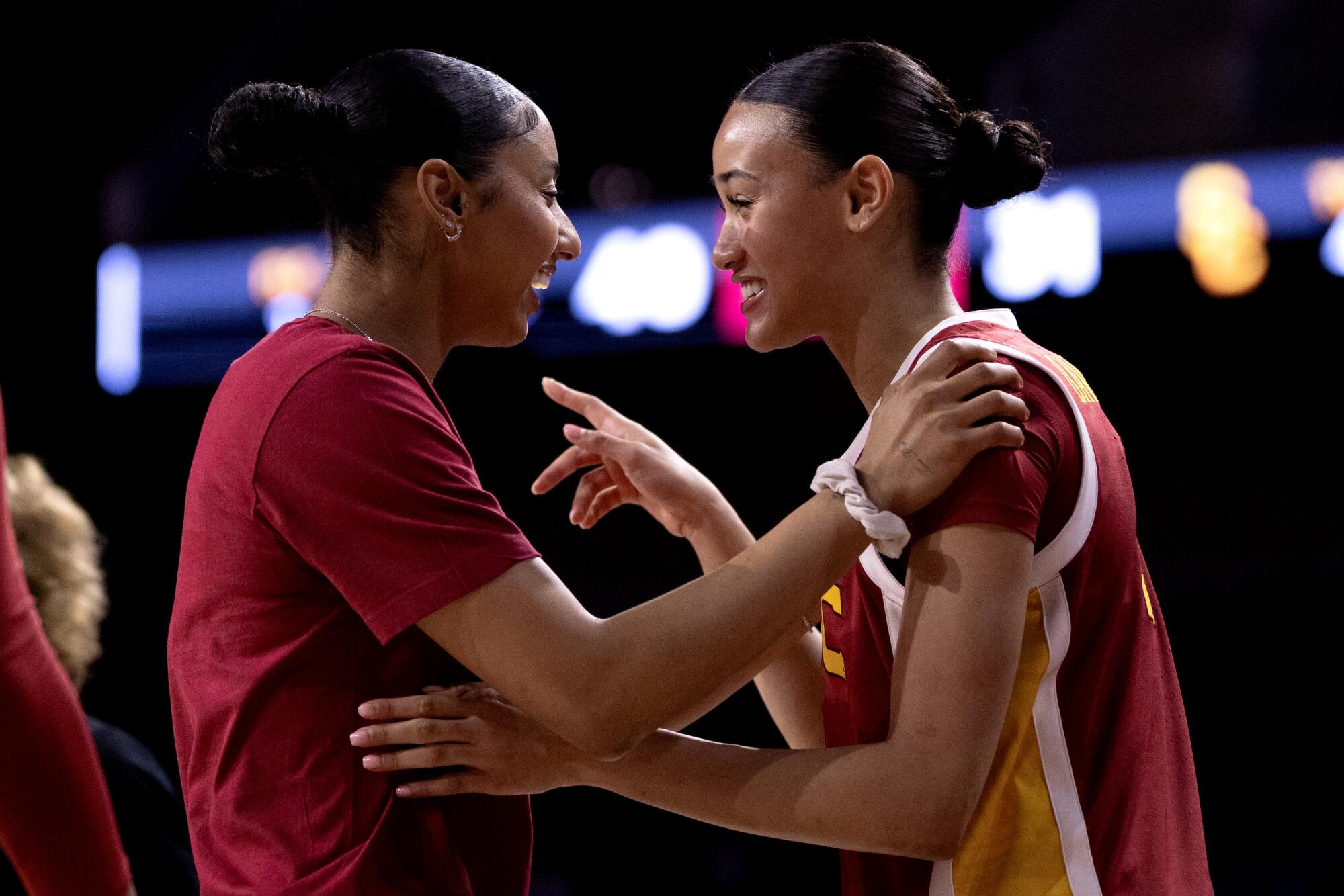 USC yıldızı JuJu Watkins (solda) ve USC guardı Jazzy Davidson kenarda etkileşim halinde.