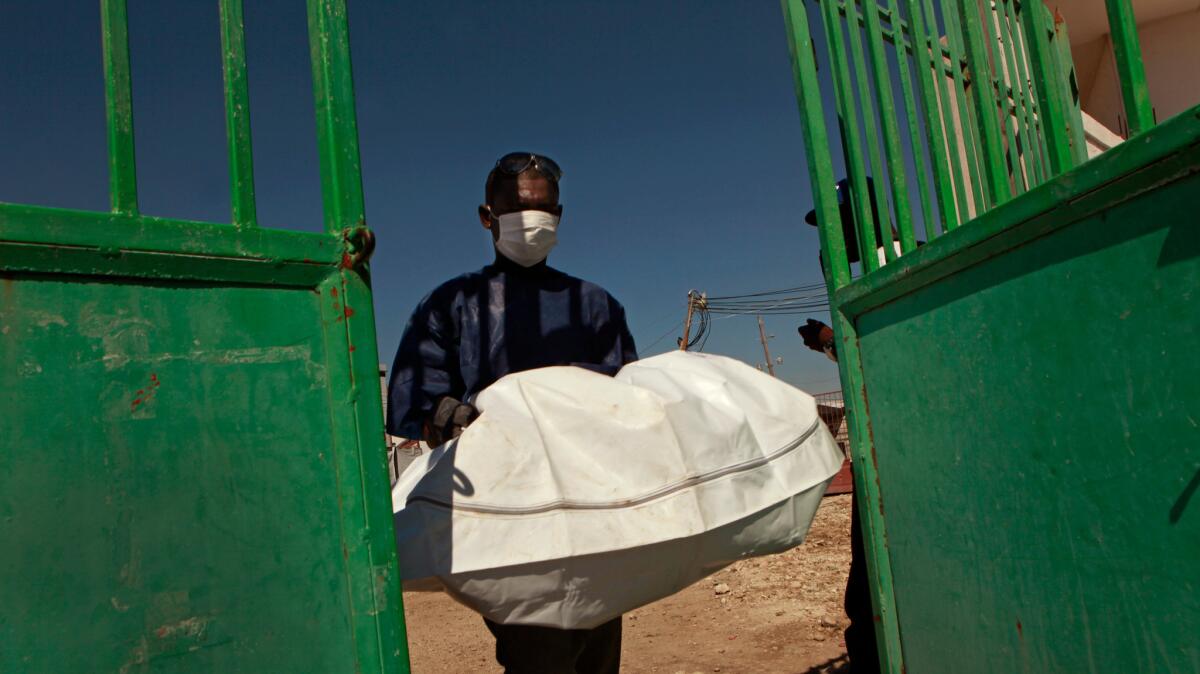 The body of a young cholera victim is removed from a hospital in Port–au–Prince, Haiti, in 2010.