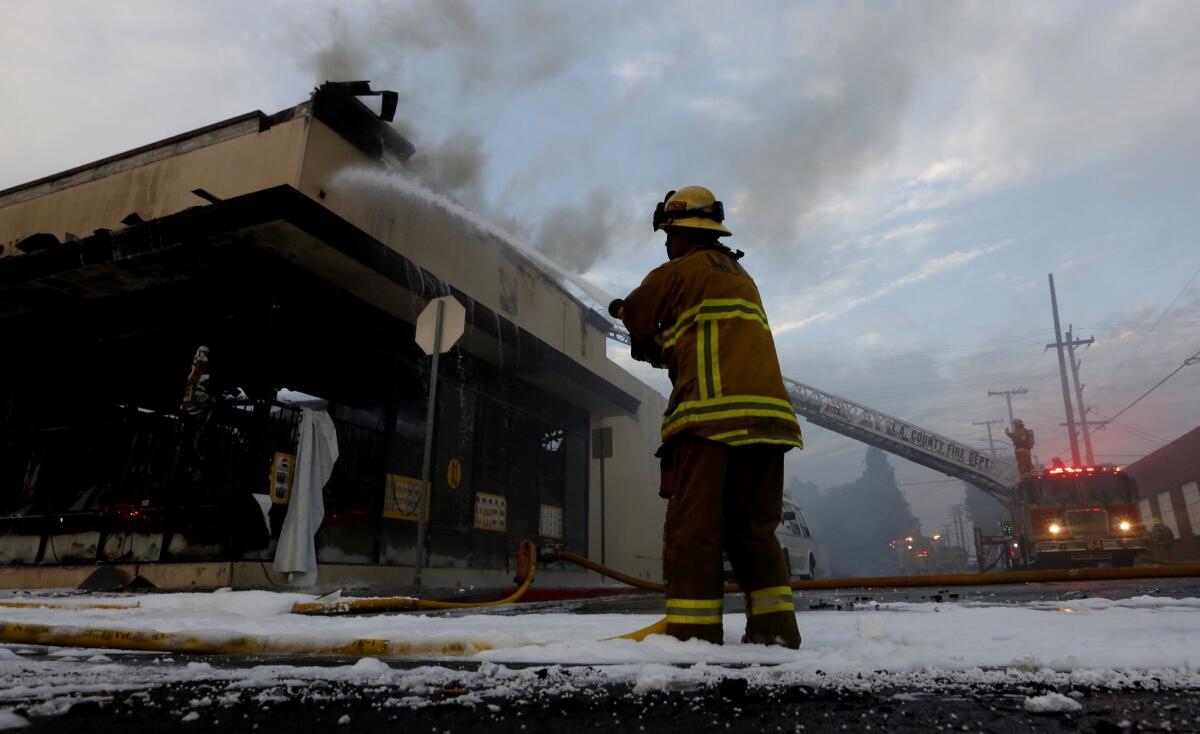 Los Angeles County firefighters battle a three-alarm commercial fire that engulfed a dollar store and spread to a next-door business in Huntington Park early Wednesday.