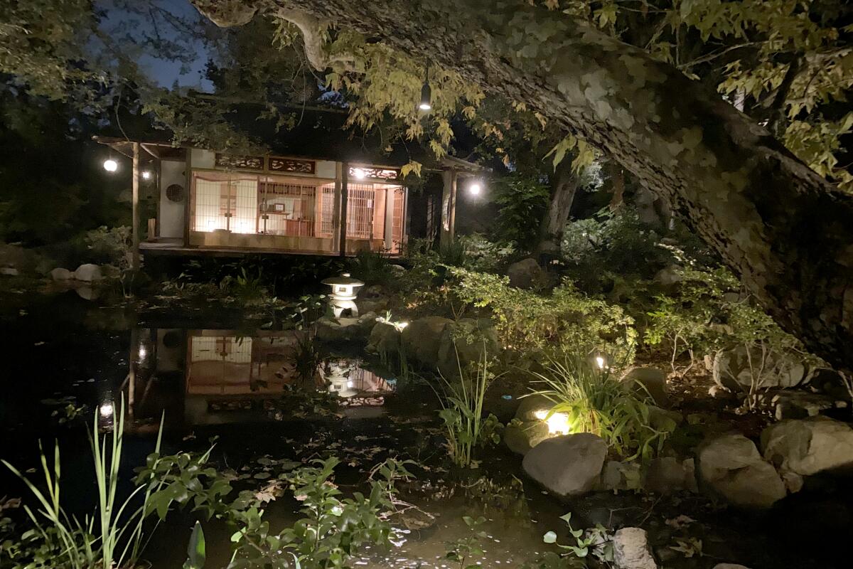 A lighted tea house in a Japanese garden