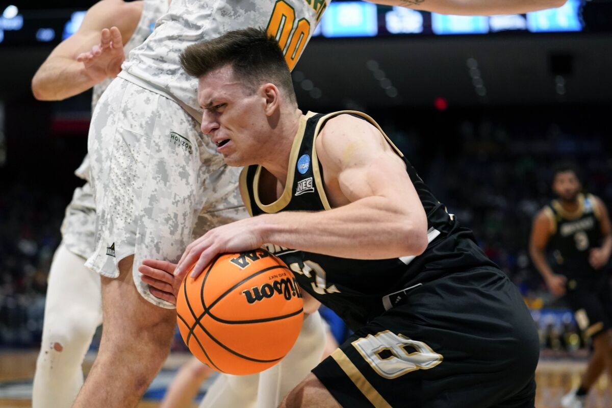 Bryant guard Peter Kiss, center right, drives past Wright State's Grant Basile (0) during the first half of a First Four game in the NCAA men's college basketball tournament, Wednesday, March 16, 2022, in Dayton, Ohio. (AP Photo/Jeff Dean)