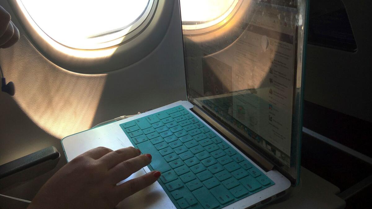 An airline passenger uses a laptop computer during a flight.