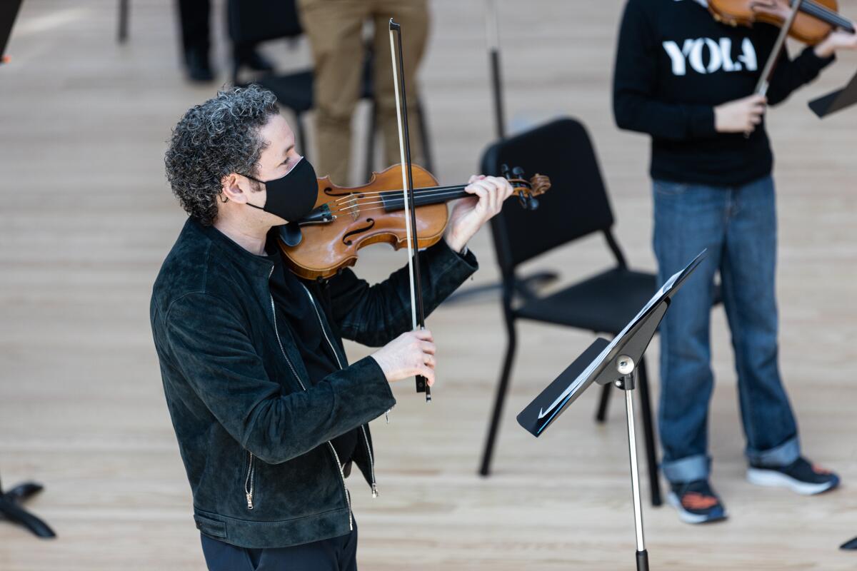 Gustavo Dudamel plays violin inside the new Frank Gehry-designed Beckmen YOLA Center.
