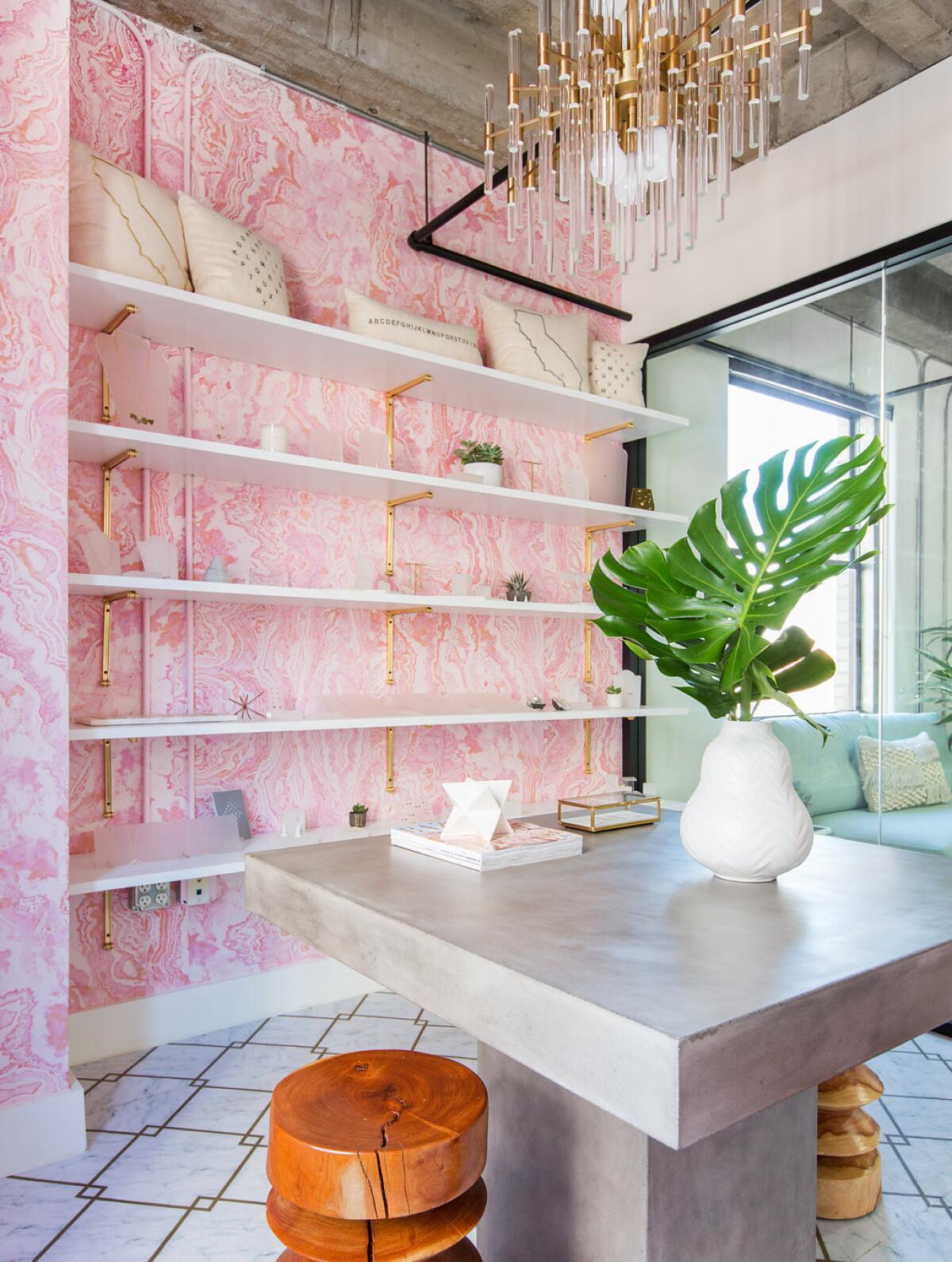 The glassed-in showroom is adorned with Pink Marble wallpaper from the Lulu & Georgia collection.