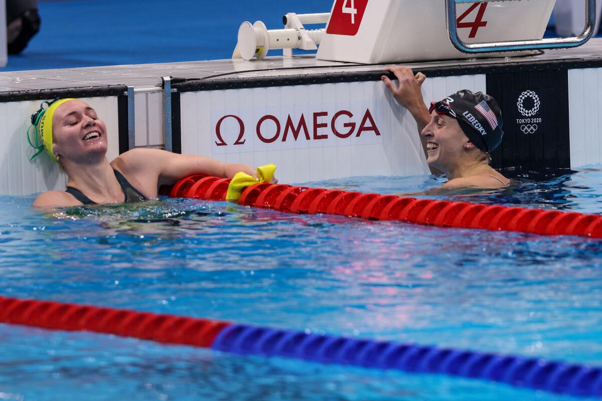 Australia's Ariarne Titmus, left, smiles after beating U.S. swimmer Katie Ledecky, right, for the gold medal.