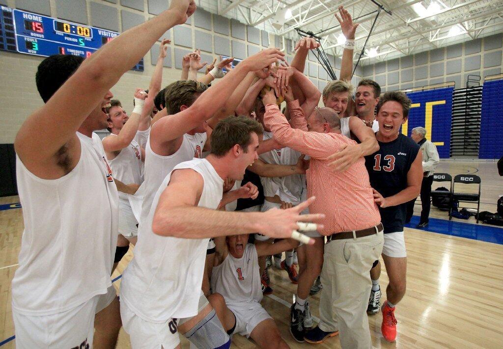 Orange Coast College head coach Travis Turner is mobbed by his players as he brings over the game ball after the Pirates beat Santa Monica in the 2014 California Community College Athletic Assn. State Championship match at Santiago Canyon College in Orange on Friday.