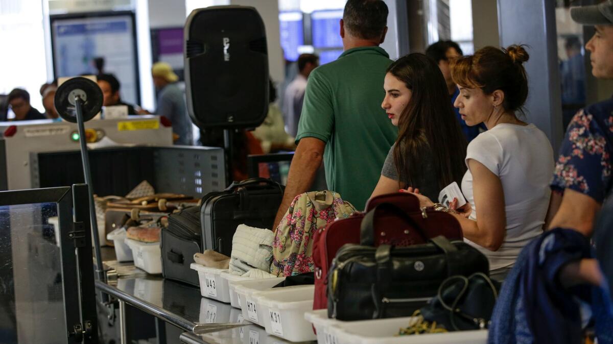 Travelers line up at a TSA checkpoint at the United Airlines terminal at Los Angeles International Airport.