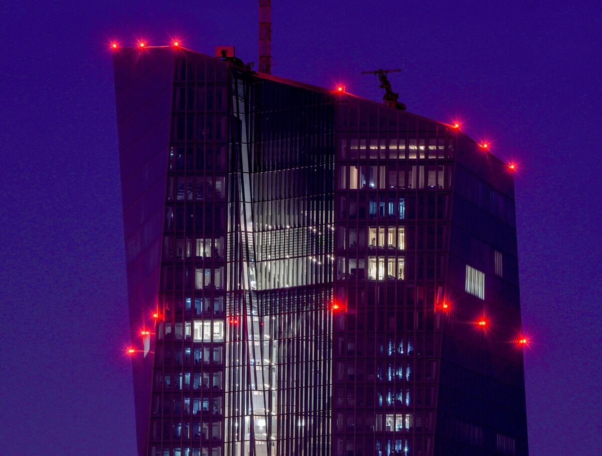 FILE - In this Tuesday, Sept. 7, 2021 file photo red lights shine on top of the European Central Bank in Frankfurt, Germany. The ECB will have a meeting of the governing council on Thursday. The European Central Bank’s governing council meets Thursday, Sept. 9, 2021 to decide monetary policy for the 19 countries that use the euro. Analysts say the central bank may ease back on its support for the economy against a background of improving economic activity. (AP Photo/Michael Probst, file)