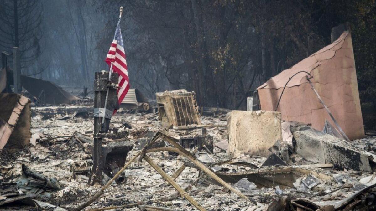 An American flag stands among burned rubble in Paradise, Calif., on Nov. 13.