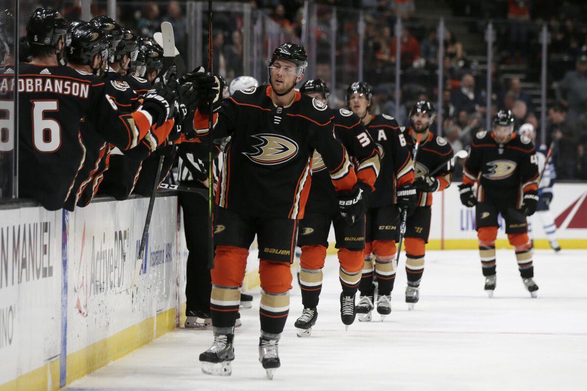 Ducks defenseman Cam Fowler, center, gets congratulations from teammates after scoring against the Winnipeg Jets during the first period on Tuesday at Honda Center.