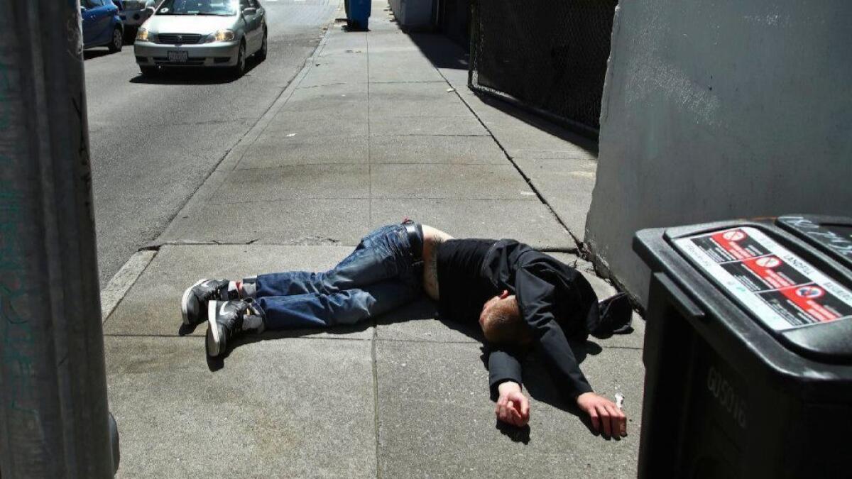 A homeless man lies on the sidewalk in San Francisco. On Thursday, the city said homelessness has jumped by 17% over the last two years, echoing similar increases across the the Bay Area.