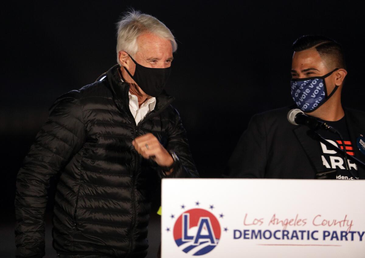 George Gascón, left, is introduced by L.A. County Democratic Party chair Mark Gonzalez at election night watch party.