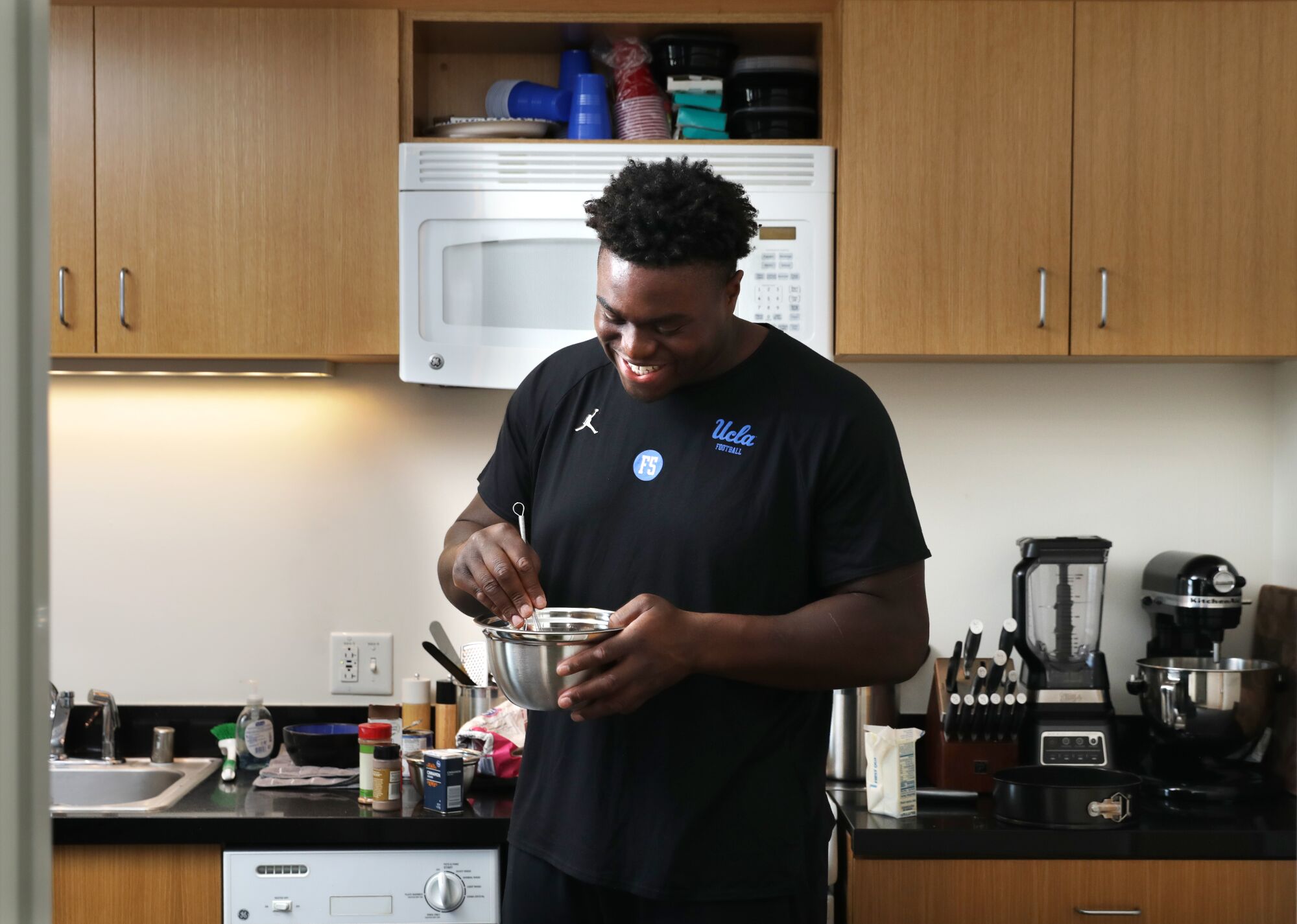 UCLA defensive lineman Otito Ogbonnia whips up a strawberry cheesecake in his apartment near campus 