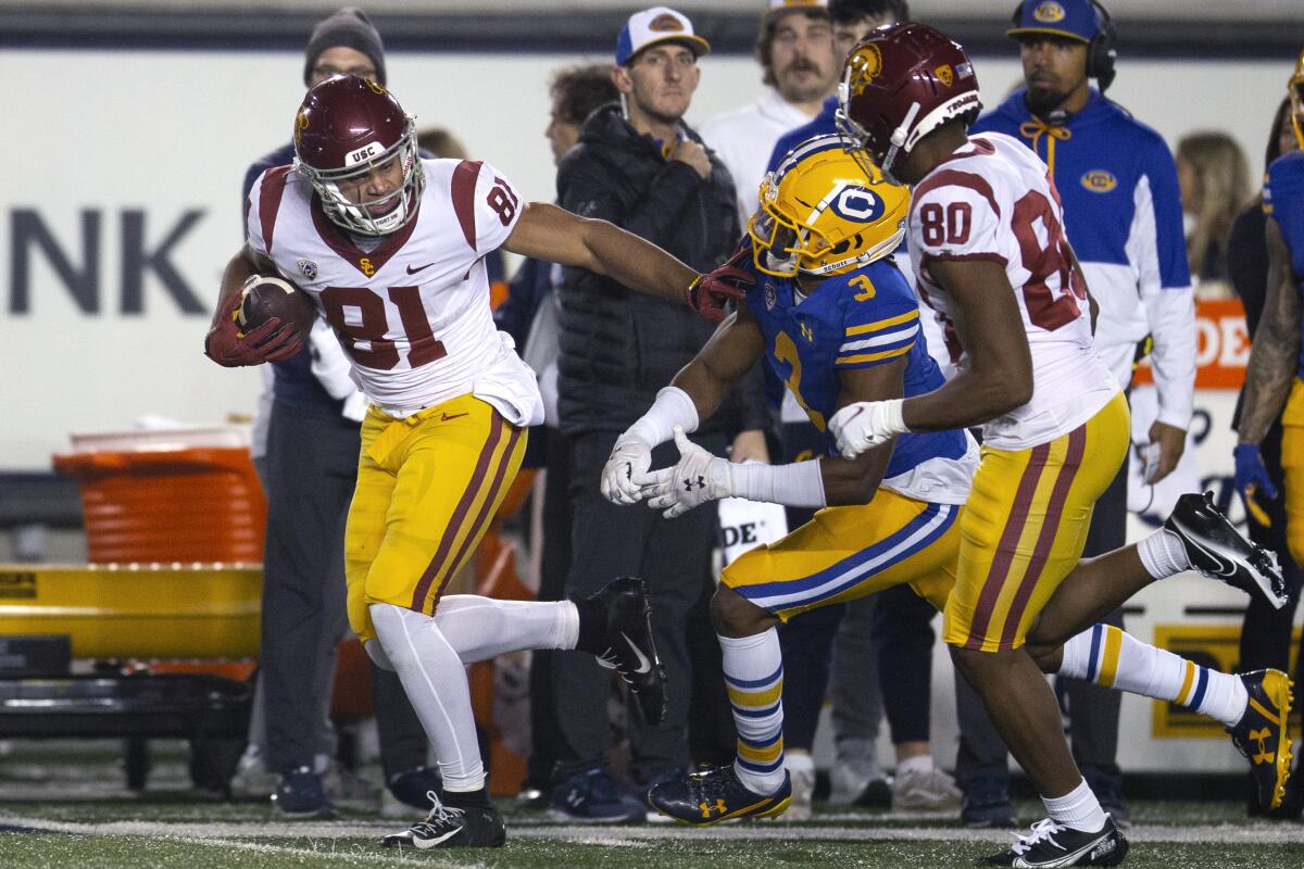 USC wide receiver Kyle Ford stiff-arms California safety Elijah Hicks on his way to scoring a touchdown.