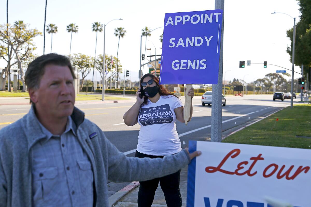Costa Mesa residents Hengameh Abraham, center, and Dale Luther, left, during a rally Tuesday outside City Hall.