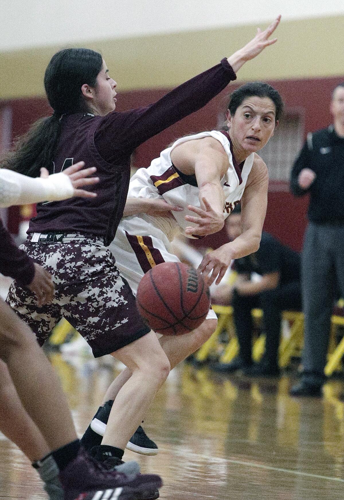 Glendale Community College's Vicky Oganyan passes inside against Antelope Valley's Sara Navarro in a Western State Conference South Division women's basketball game Wednesday at Glendale.