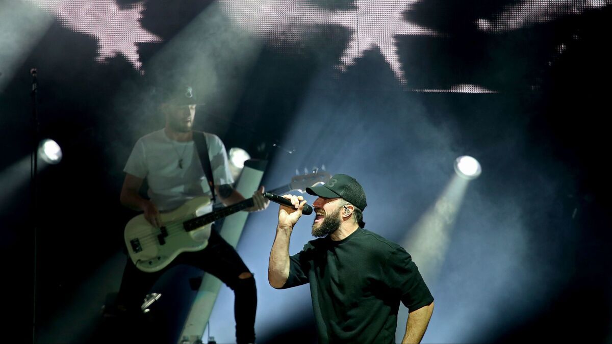 Sam Hunt, with microphone, performs Tuesday night at the Greek Theatre.