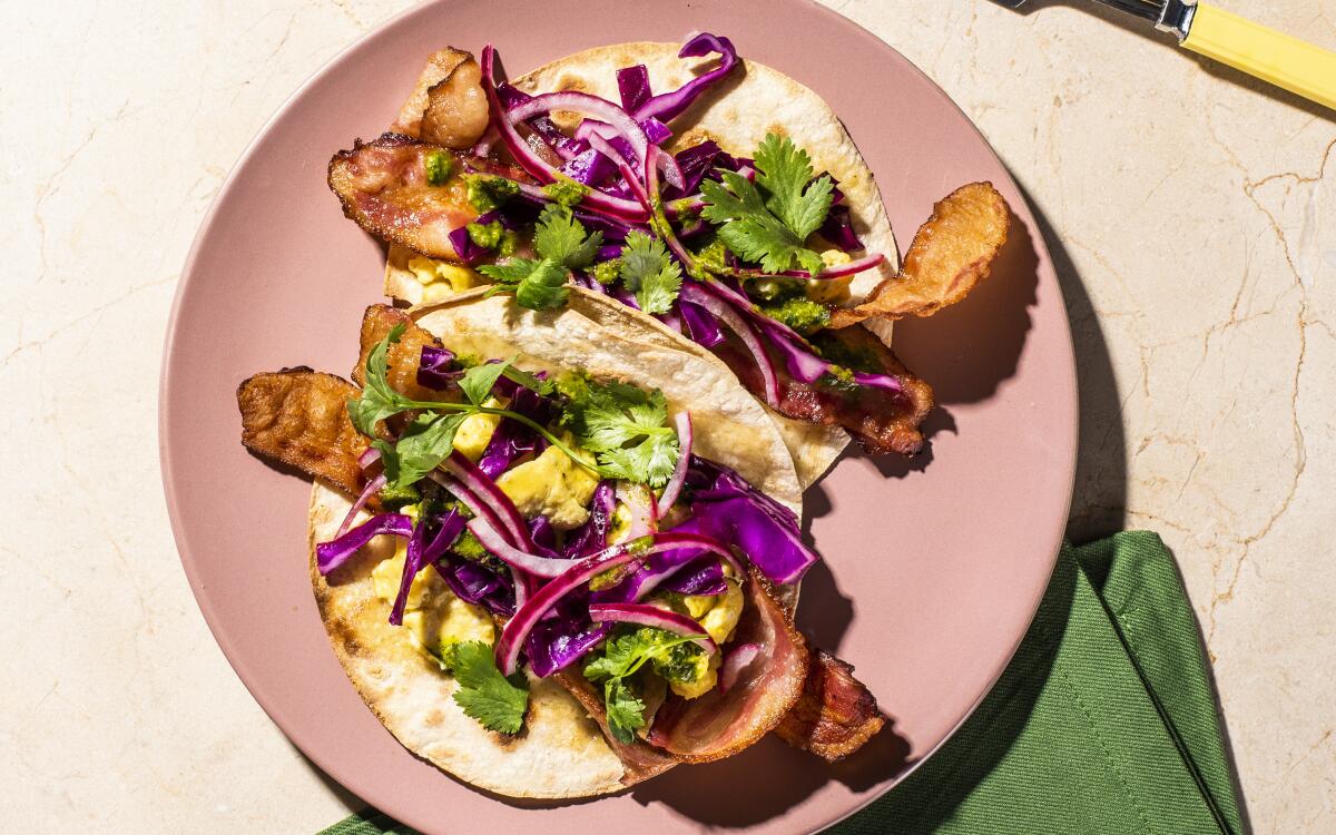 Bacon and eggs are topped with crunchy slaw and herbs in these weeknight, breakfast-for-dinner tacos.