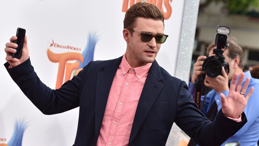 Phone in hand, Justin Timberlake arrives at the premiere of "Trolls" in Los Angeles on Sunday.
