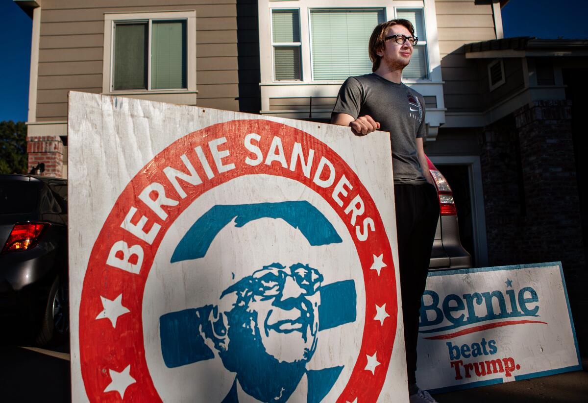 Ben Albrecht, a former Bernie Sanders, supporter poses for a portrait with his Bernie Sanders for President.