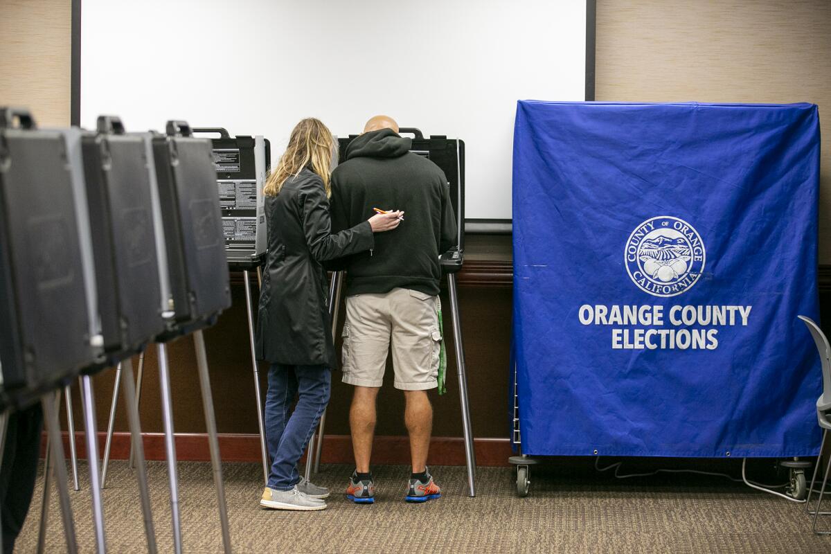Nov. 2022 photo of a couple casting their ballot at Huntington Beach City Hall.
