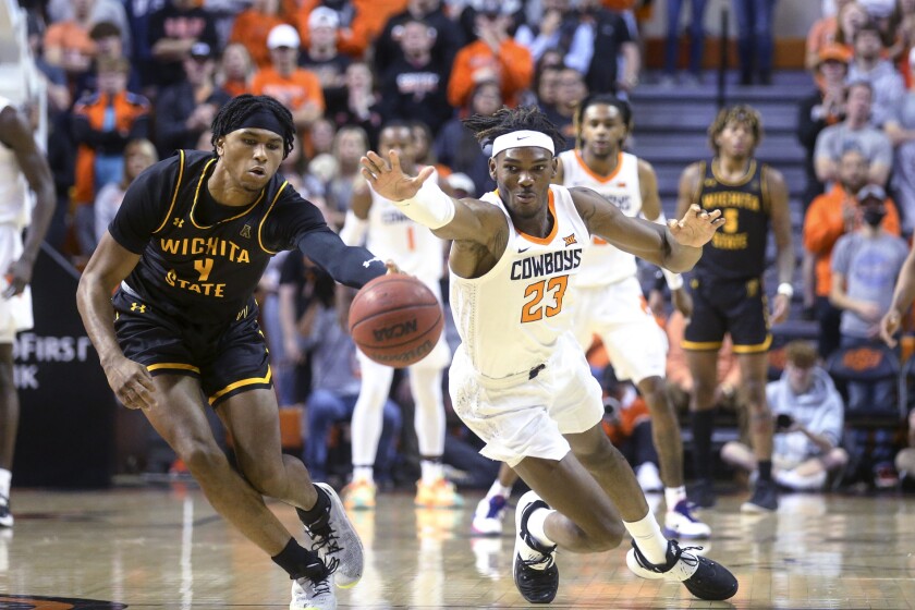 Wichita State guard Ricky Council IV (4) and Oklahoma State forward Tyreek Smith (23) attempt to get possession of the ball during an NCAA college basketball game Wednesday, Dec. 1, 2021, in Stillwater, Okla. (Ian Maule/Tulsa World via AP)