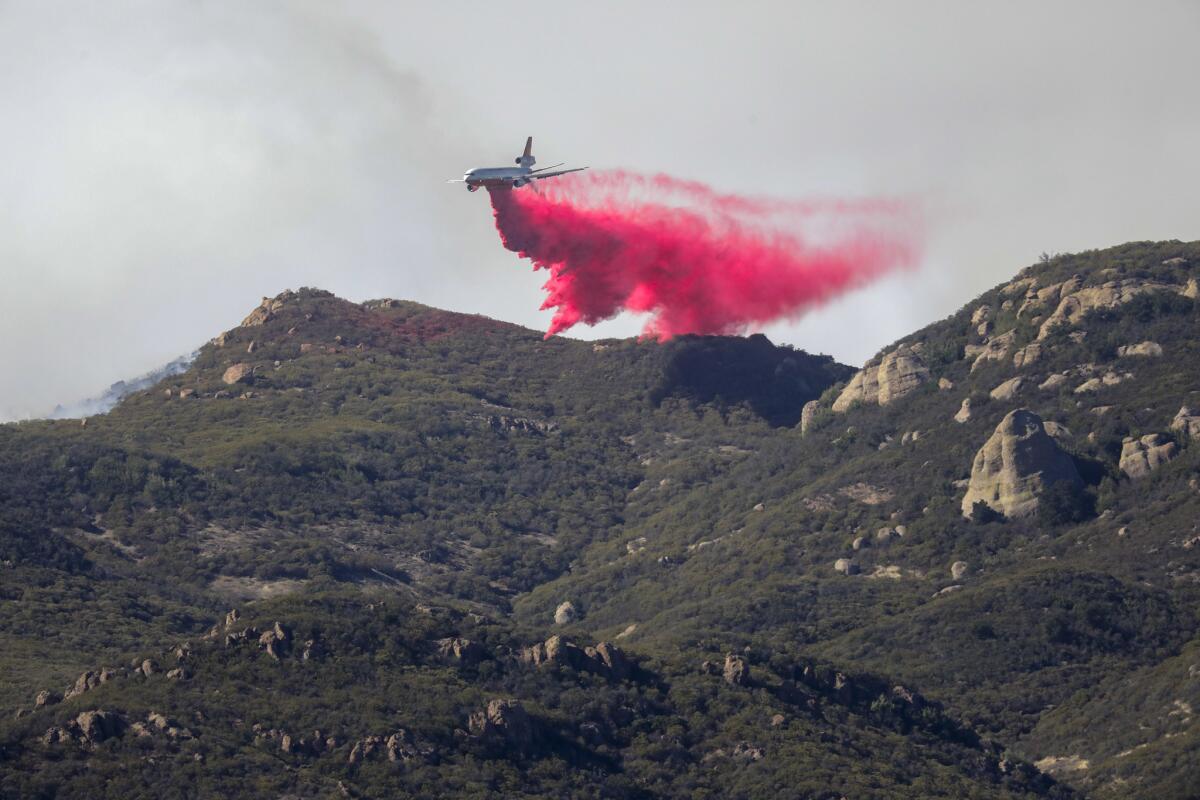 A planes drops fire retardant above the Lake Sherwood community on Tuesday morning.