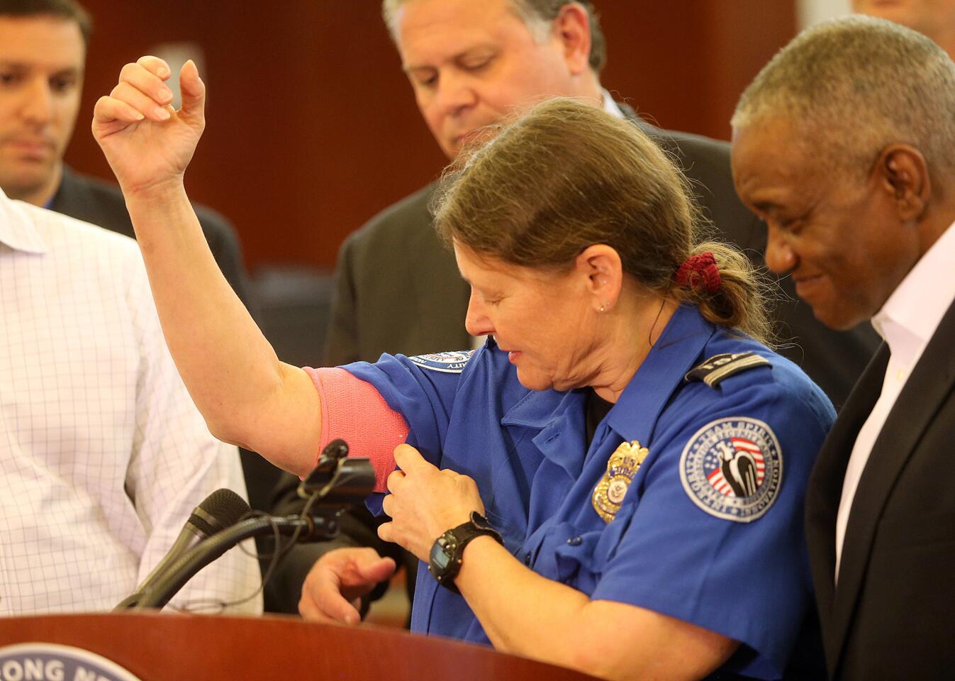 During a press conference March 21, TSA agent Carol Richel shows the gunshot wound to the arm she suffered as she was chased by a machete-wielding man at a security checkpoint in Kenner, La.