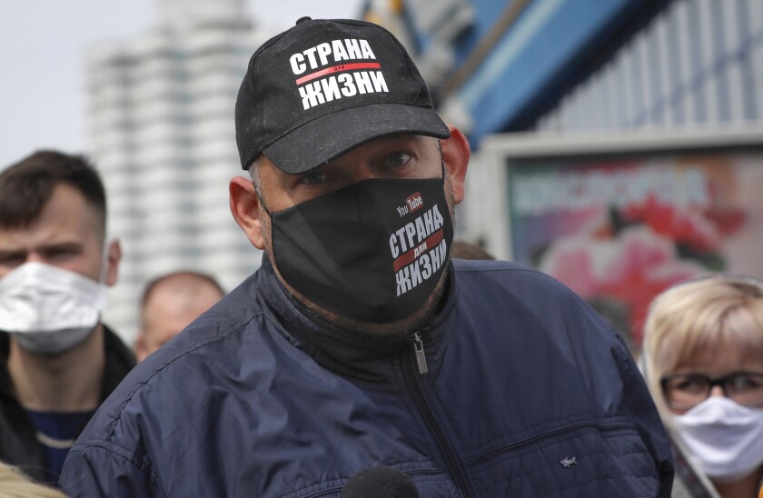 FILE - Blogger Siarhei Tsikhanouski, wearing a face mask to protect against coronavirus, speaks to people gathered to sign up and support potential presidential candidates in the upcoming presidential elections in Minsk, Belarus, Sunday, May 24, 2020. A court in Belarus on Tuesday, Dec. 14, 2021 sentenced the husband of the country's opposition leader to 18 years in prison, six months after the trial began behind closed doors. The charges against Siarhei Tsikhanouski included organizing mass unrest and inciting hatred and have been widely seen as politically motivated. (AP Photo/Sergei Grits, File)