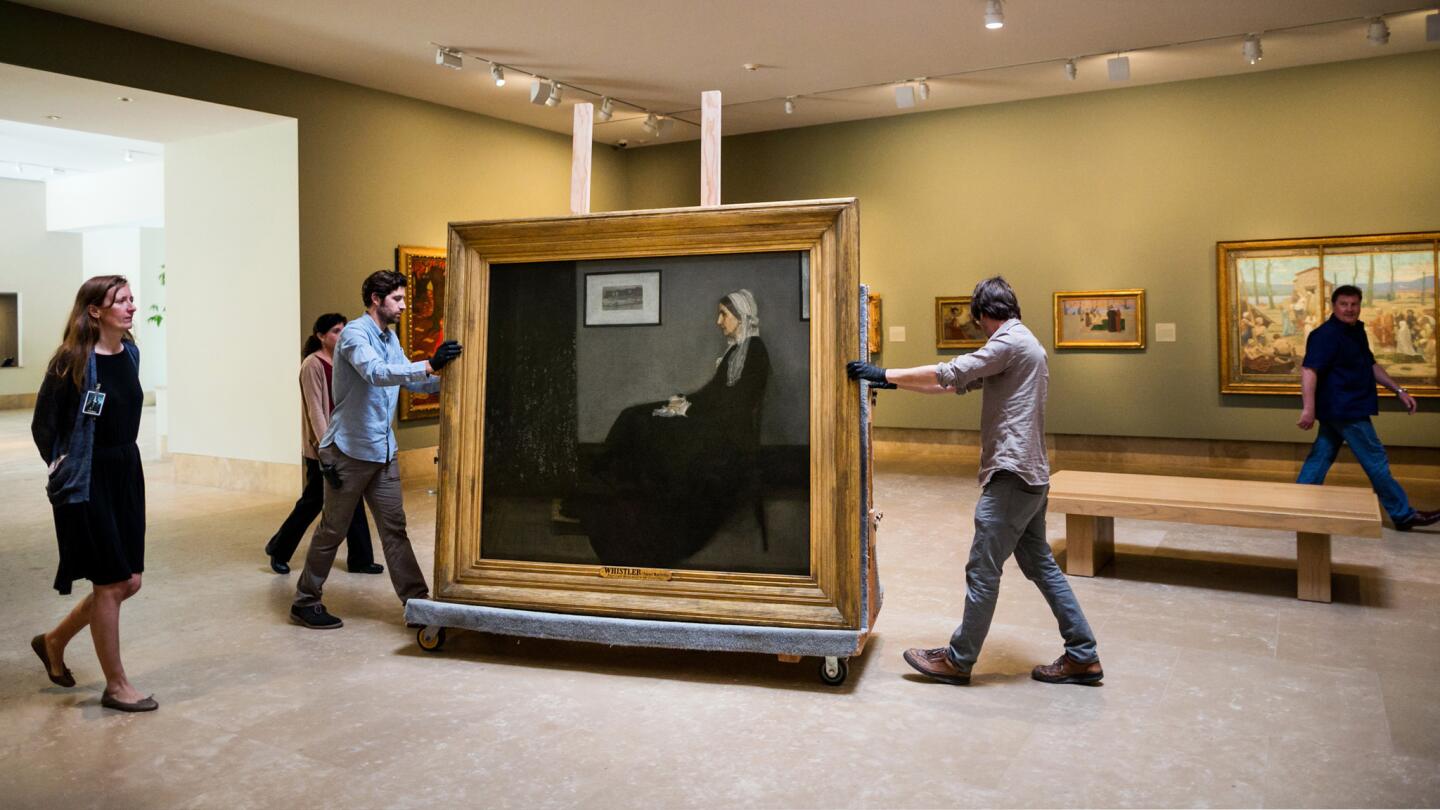 PASADENA, CALIF. -- MONDAY, MARCH 23, 2015: Museum workers wheel in the James Abbott McNeill Whistler's painting, "Arrangement in Grey and Black No.1," also famous under its colloquial name Whistler's Mother, into a gallery space where it will be mounted for display at the Norton Simon Museum in Pasadena, Calif., on March 23, 2015. Part of a 19th century masterpiece swap between the MusÃ©e d'Orsay in Paris and the Norton Simon Museum, these paintings, James Abbott McNeill Whistler's, "Arrangement in Grey and Black No.1," also famous under its colloquial name Whistler's Mother, Ãdouard Manet'Â's Â""Ãmile Zola" and Paul CÃ©zanneÂ''s "Â"The Card Players"Â" will be available for viewing at the Norton Simon museum from March 27 through June 22. (Marcus Yam / Los Angeles Times)
