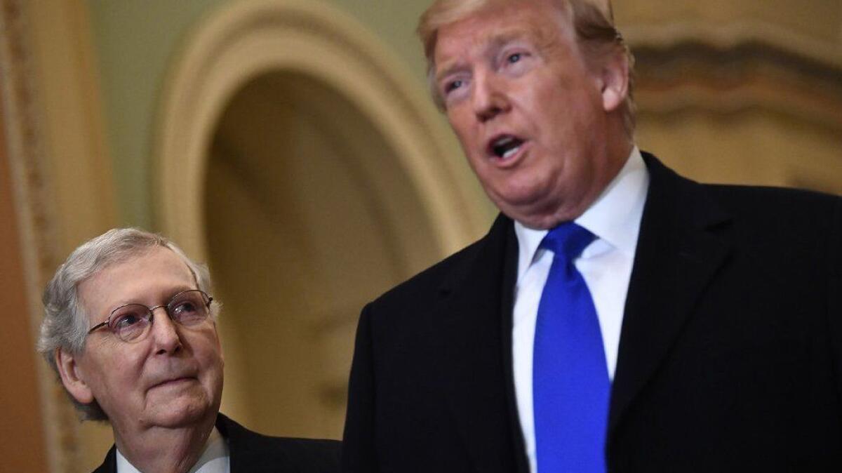 Senate Majority Leader Mitch McConnell, left, looks on as President Trump speaks to reporters on Capitol Hill on March 26.