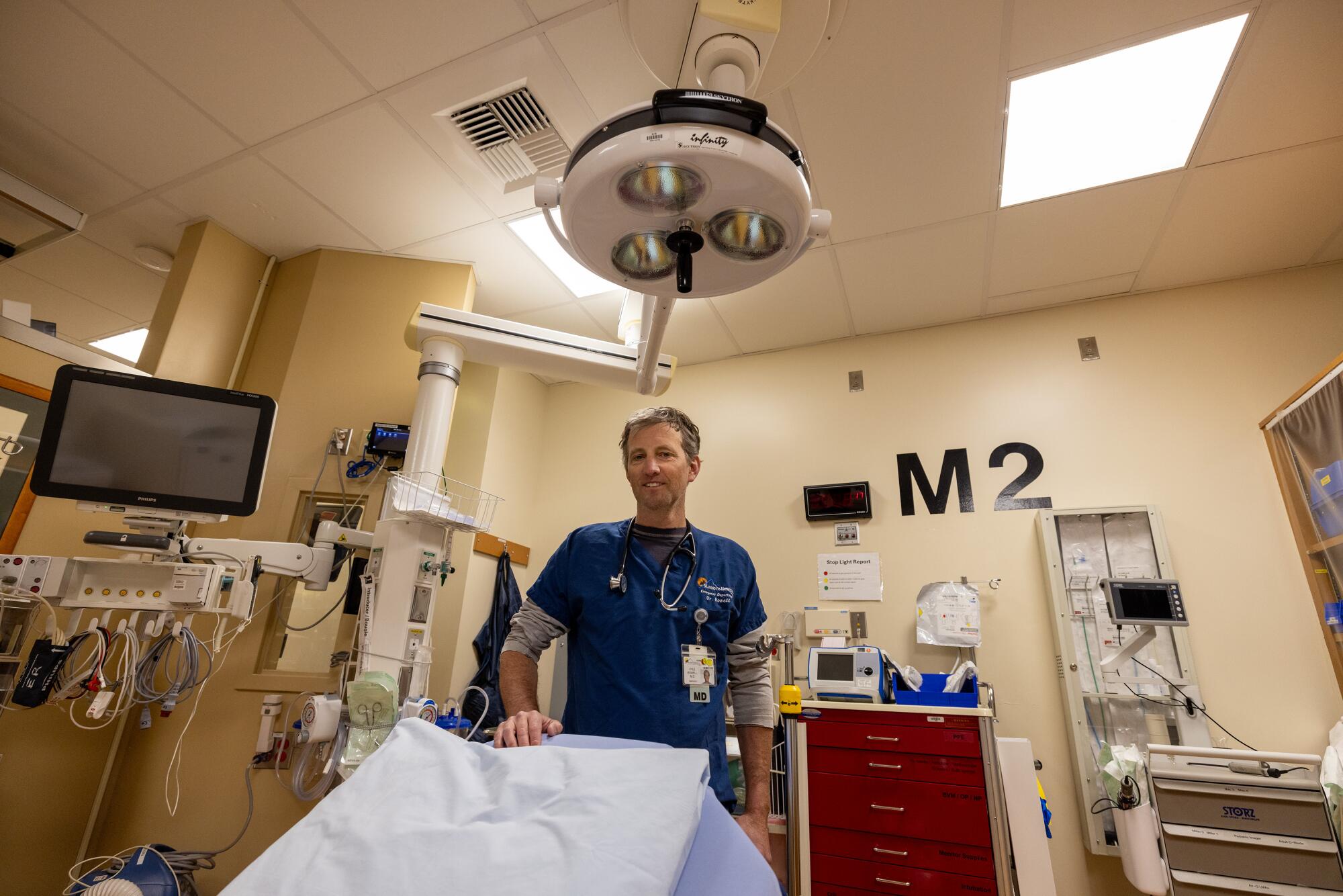 An doctor stands in an ER unit.  