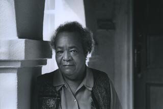 Samella Lewis is seen in a black and white photo leaning against a column and framed by an arch