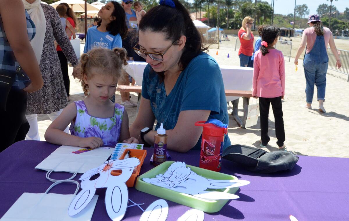  Jenny Kirkland helps her daughter, Bree, 4, decorate an Easter bag to collect plastic eggs.