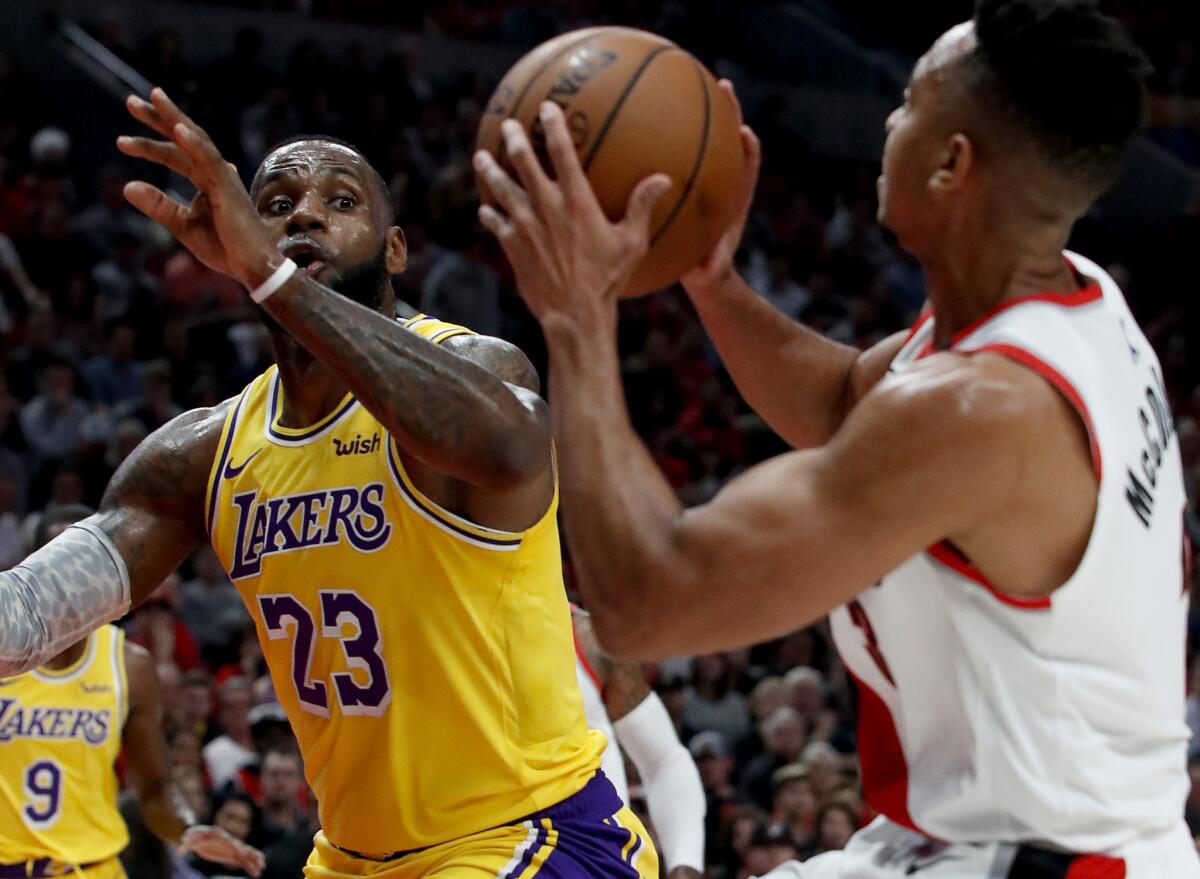 LeBron James prepares to challenge a shot by Trail Blazers guard CJ McCollum in the season opener Thursday.