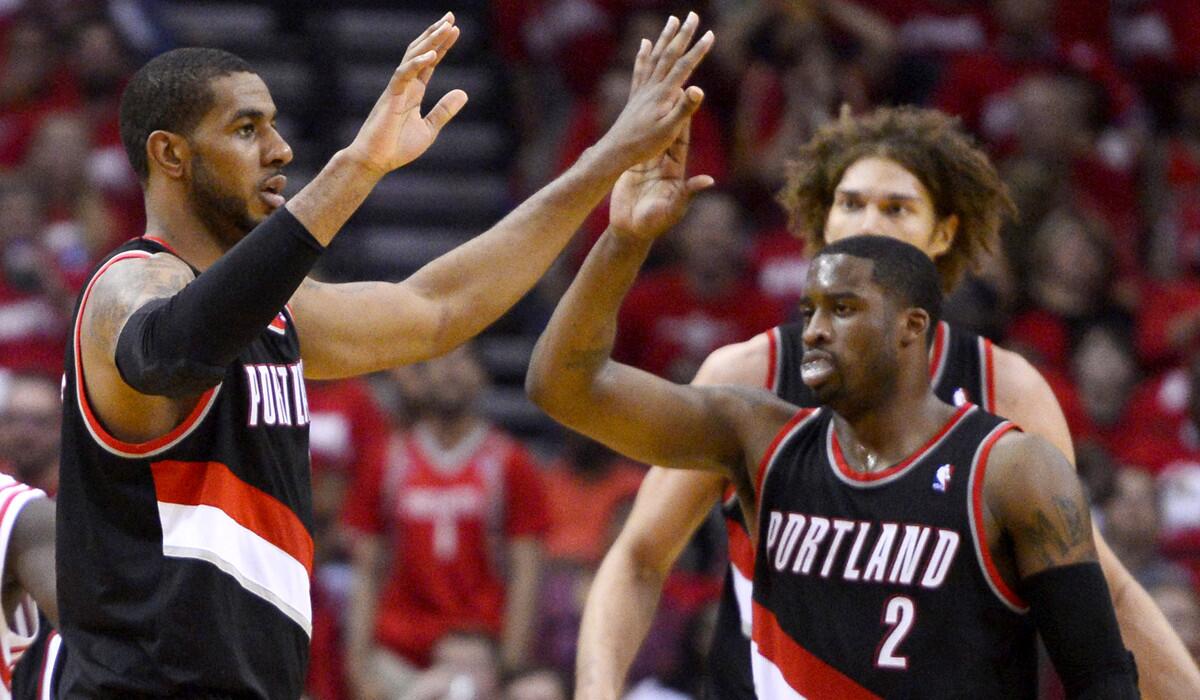 Trail Blazers power forward LaMarcus Aldridge, left, celebrates with teammates Wesley Matthews (2) and Robin Lopez after making a three-point shot against the Rockets on Wednesday night in Houston.