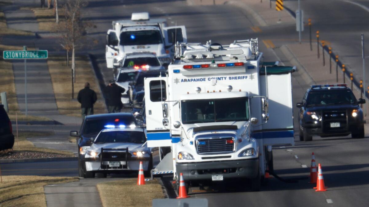 An investigator heads to the scene of shooting Sunday in Highlands Ranch, Colo.