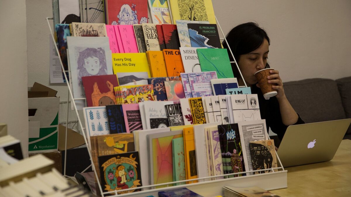 Denice Diaz, co-owner of Other Books, at the check-out table.