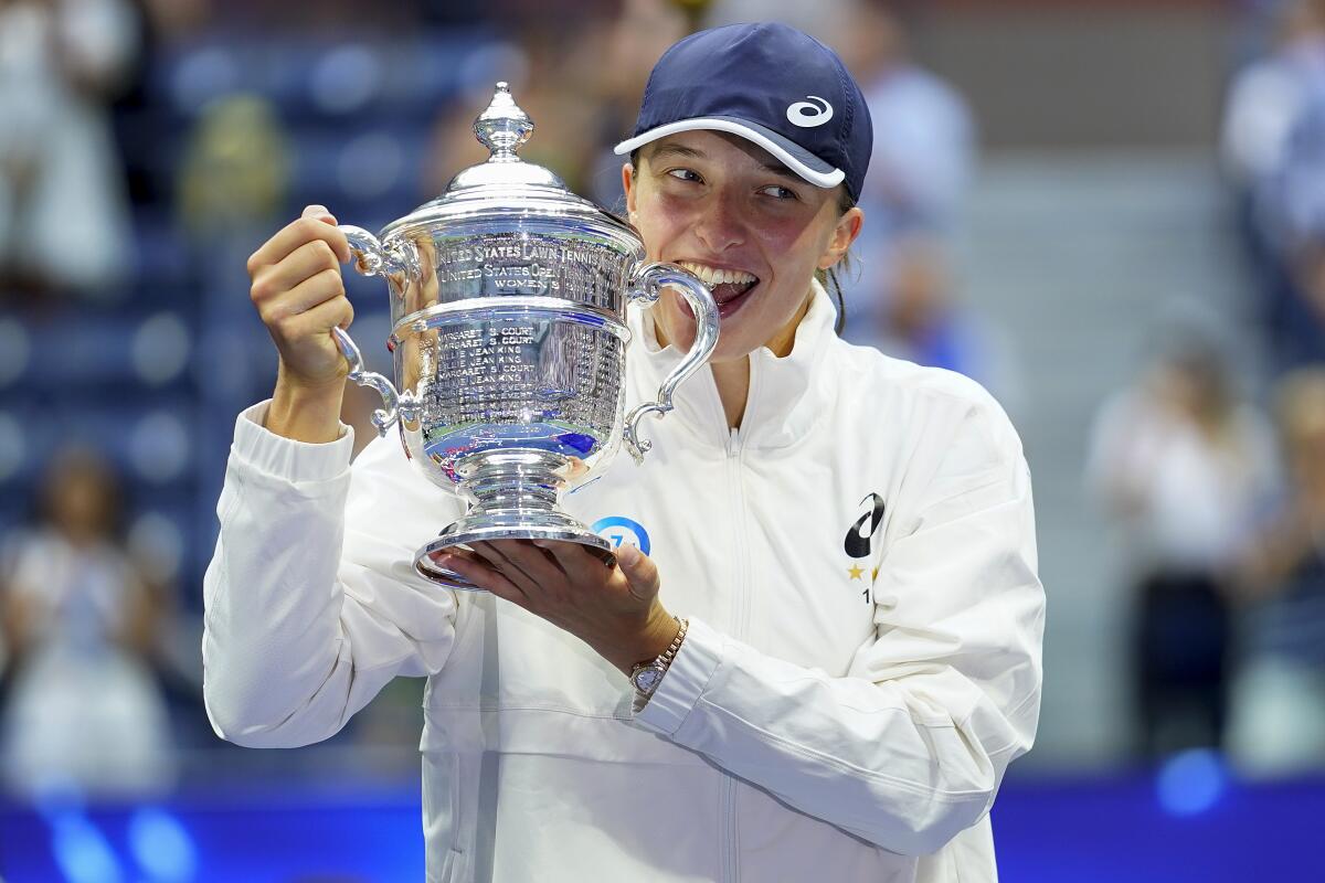Iga Swiatek, of Poland, poses for a photo with the championship trophy after winning U.S. Open women's singles title.