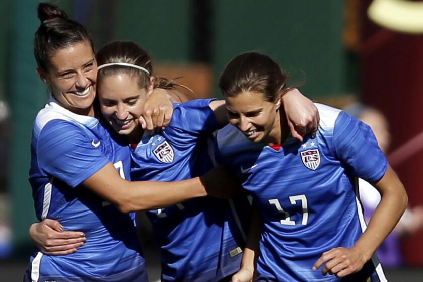 United States' Morgan Brian, center, is congratulated by teammates Ali Krieger, left, and Tobin Heath, after scoring during the second half of an exhibition soccer match against New Zealand on April 4. The trio are on the U.S. Women's World Cup roster, which Coach Jill Ellis announced on Tuesday.