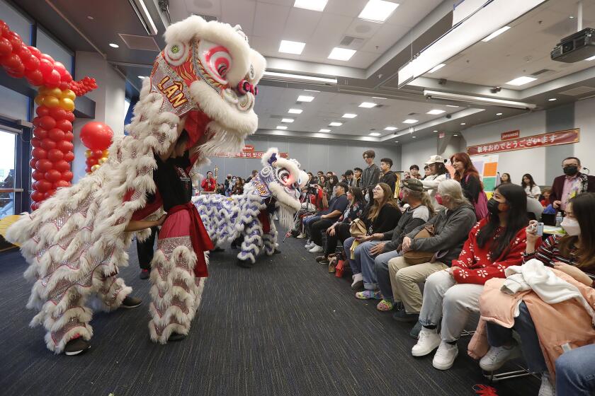 Members of the Chinese Southern Wind lion dance team, perform for guests at the annual Lunar New Year celebration at the student center at UCI on Tuesday.